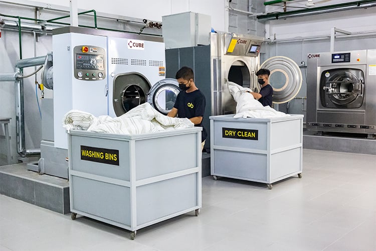 Workers handling washing and dry cleaning in an industrial facility.